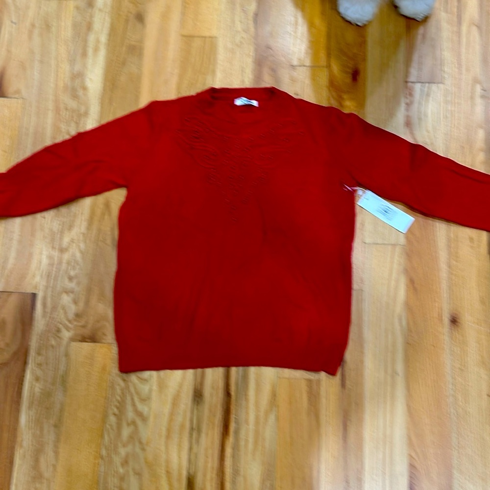 Red sweater by Victoria with design on the front